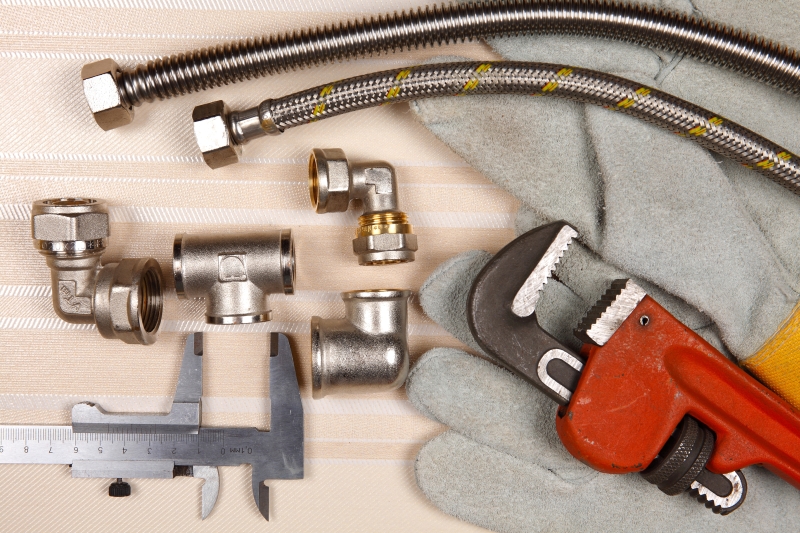Plumber working on pipes in a Brentford home